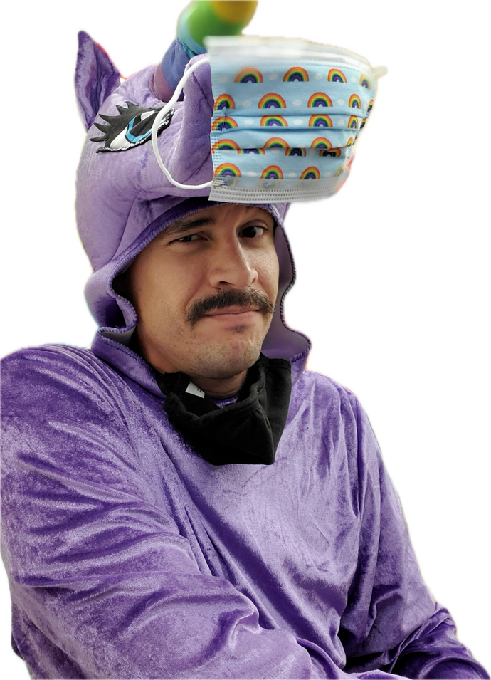 The Comparable Jason Sims A man with dark facial hair is wearing a purple unicorn mask that has a rainbow covid-style mask on it's head.